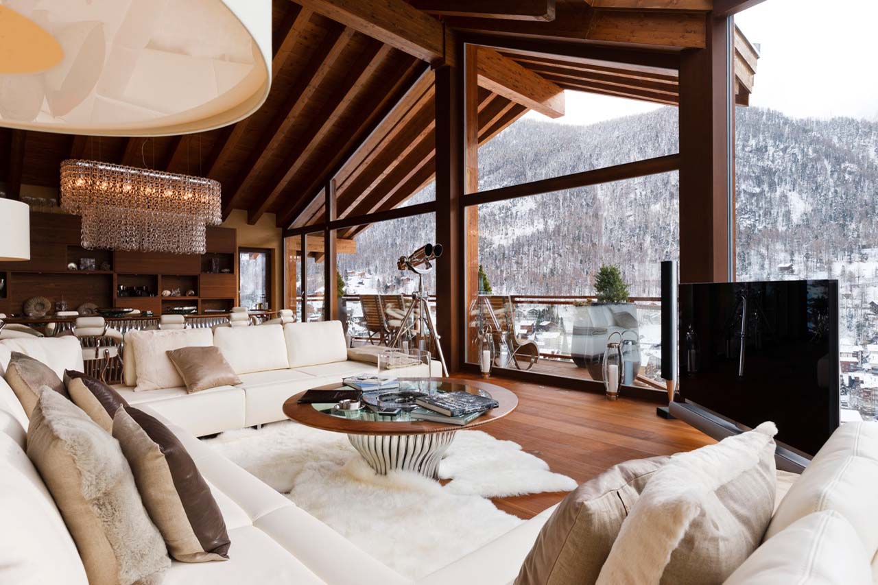 Living room with floor to ceiling windows framing the mountain views at Chalet Zermatt Peak in Zermatt