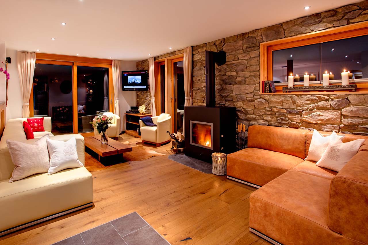 Chalet Gemini Zermatt living room at night with fireplace and TV